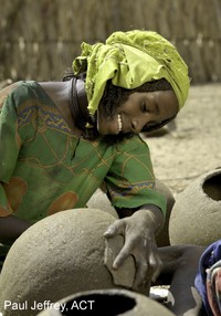 girl working with water jugs; photo by Paul Jeffrey, ACT