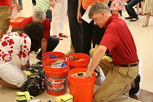man filling orange bucket with supplies; photo by Preston Hollow PC