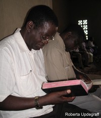man looks at Bible; photo by Roberta Updegraff