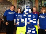 volunteers standing by blue tshirts with tags showing mission locations