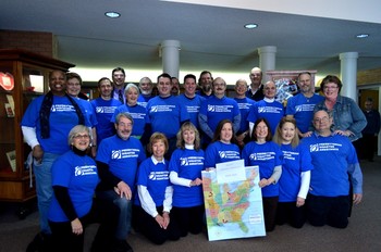 volunteer team wearing blue shirts with U.S. map in front of them