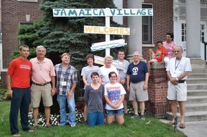 team in front of village sign