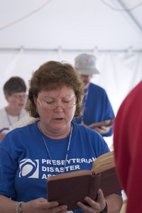 woman sings from hymnbook; photo by Barry Carlin