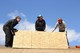 three volunteers working on the roof; photo by Hannah Keller