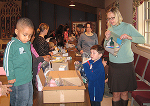 children and adults assembling kits around a table
